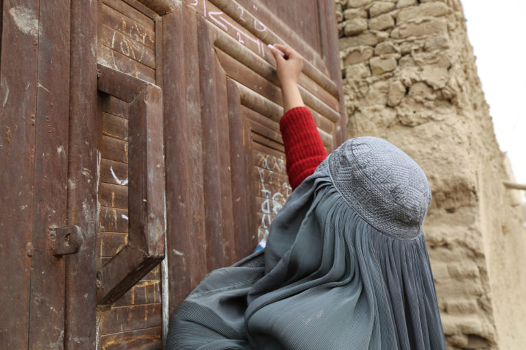 Female vaccinator marks house after polio teram visit in Loya Wala, Kandahar, Afghanistan in December 2017