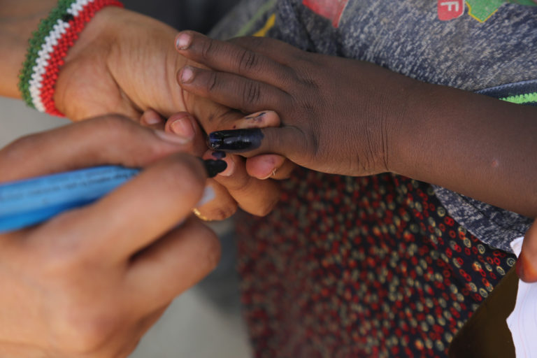 A member of Volunteer Vaccination Team finger marks a young boy  after he received double doses of the oral polio vaccine during the national immunization campaign in Hargeisa, Somaliland on 26 March 2019. WHO Photo